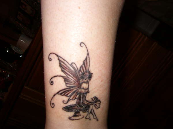 Black Ink Fairy On Mushroom Tattoo Design For Forearm