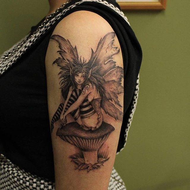 Black Ink Fairy On Mushroom Tattoo On Women Left Upper Arm