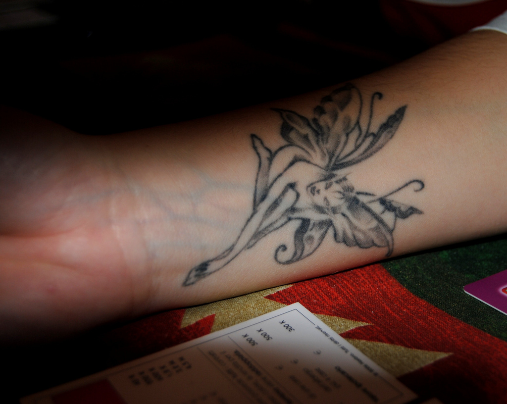 Black Ink Fairy Tattoo On Forearm