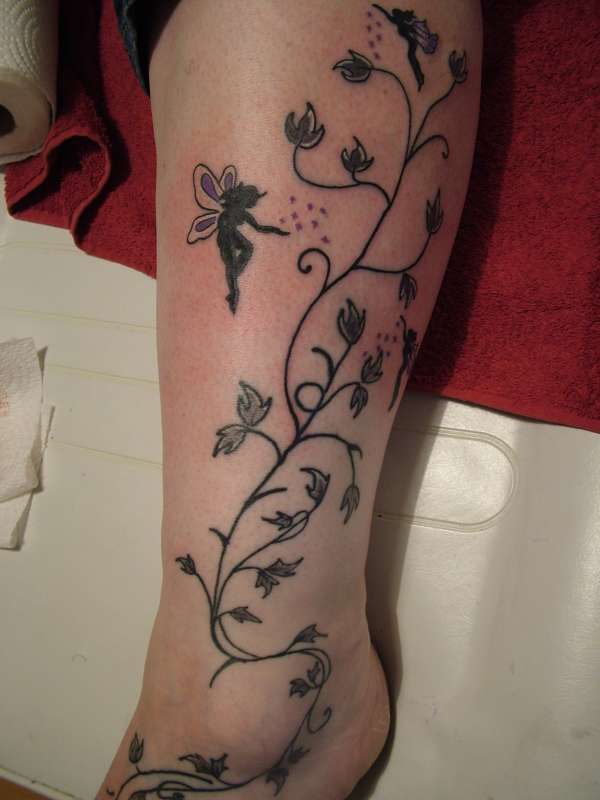 Black Ink Fairy With Fairy Dust And Flowers Tattoo On Left Leg