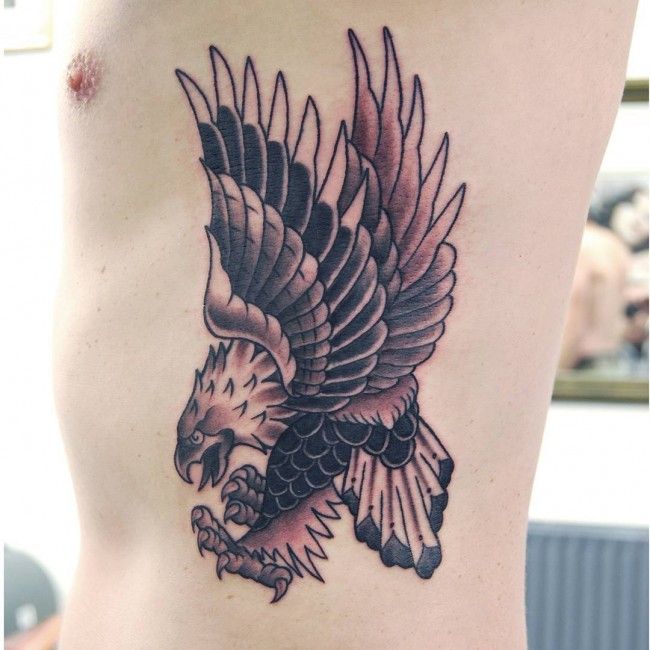 Black Ink Flying Eagle Tattoo On Left Side Rib