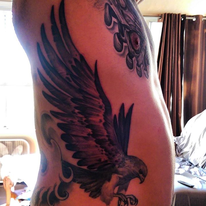 Black Ink Flying Eagle Tattoo On Man Right Side Rib