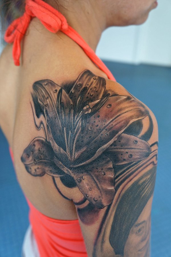 Black Ink Lily Flower Tattoo On Girl Right Back Shoulder