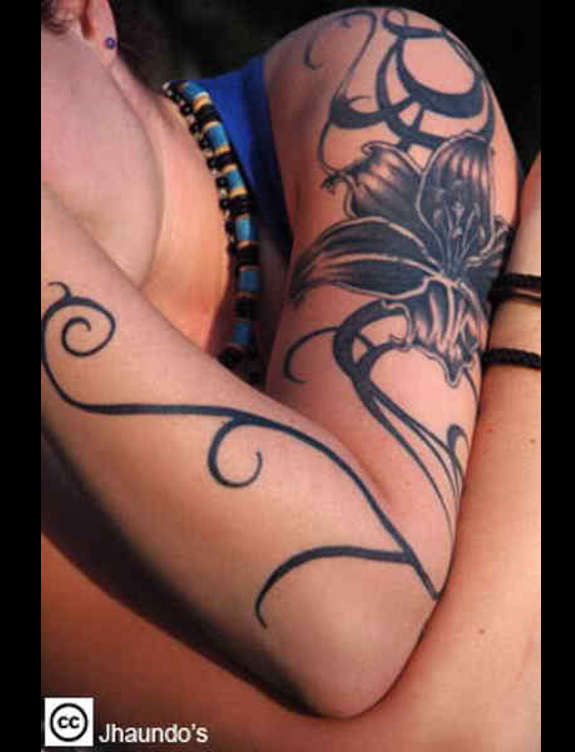 Black Ink Lily Flower Tattoo On Left Upper Arm