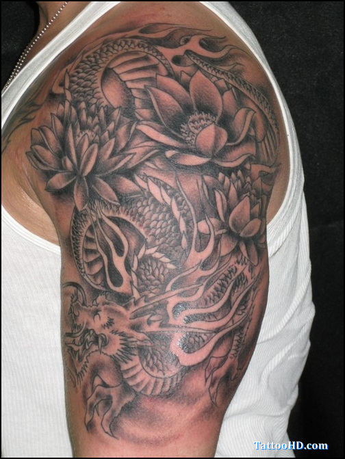 Black Ink Lotus Flowers With Dragon Tattoo On Man Left Upper Arm