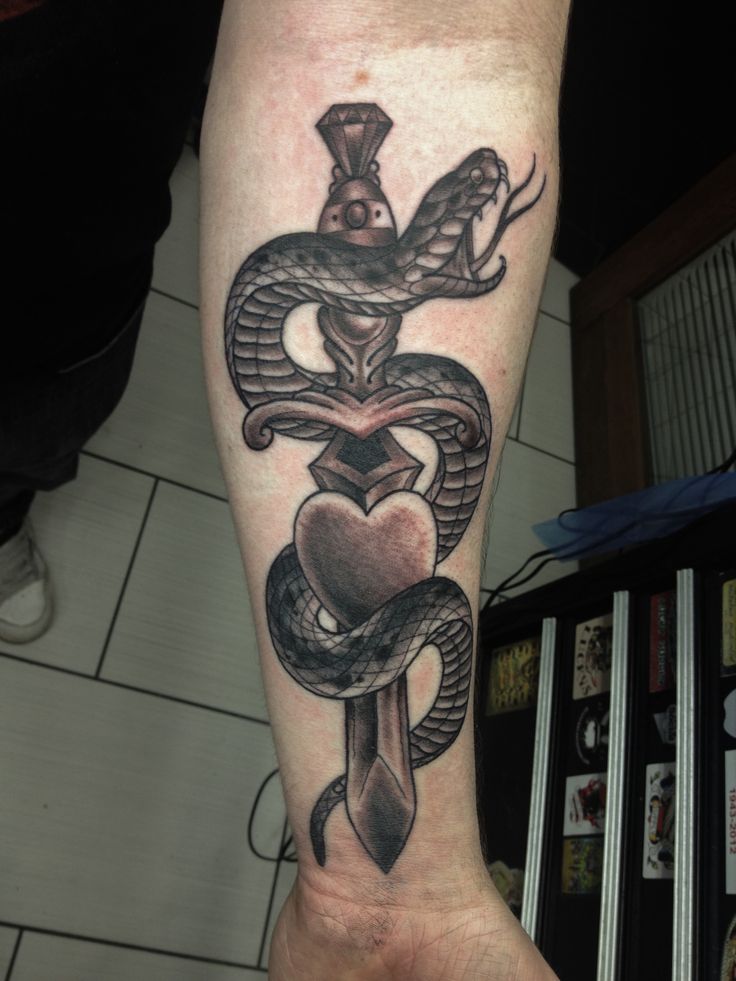Black Ink Snake With Dagger Tattoo On Left Forearm