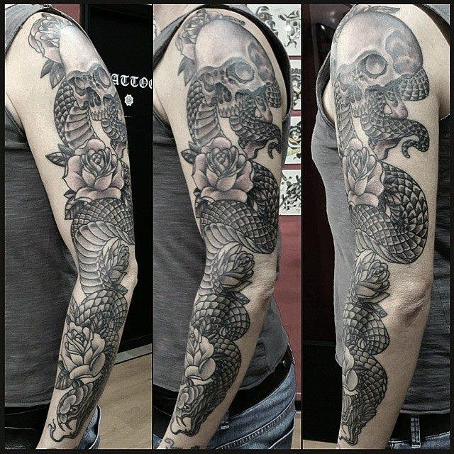 Black Ink Snake With Skull And Roses Tattoo On Man Left Full Sleeve