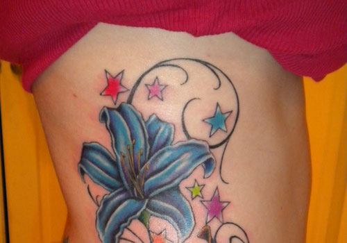 Blue Lily Flower And Colored Stars Tattoo On Side Rib