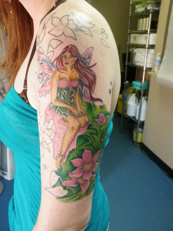 Colorful Fairy With Flowers Tattoo On Women Left Half Sleeve