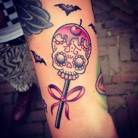 Flying Bats And Cherry Skull Lolipop Tattoo On Arm