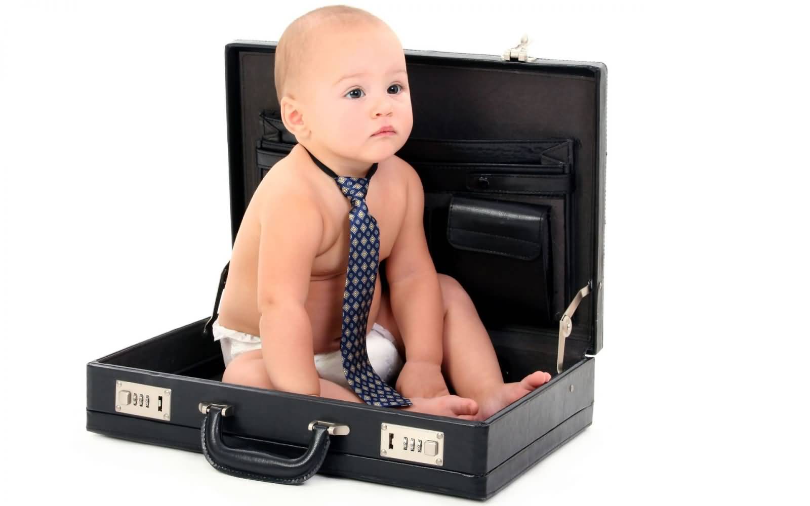 Funny Kid Wearing Tie Sitting In Briefcase