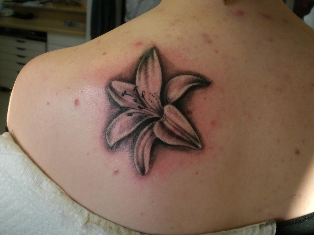 Grey And Black Lily Flower Tattoo On Left Back Shoulder