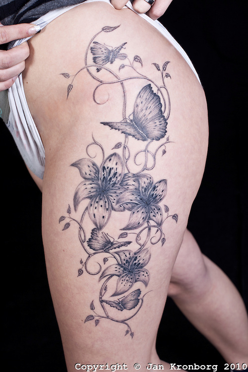 Grey Ink Lily Flowers With Butterflies Tattoo On Girl Left Side Thigh