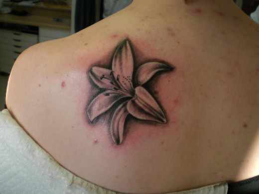 Grey Ink Lily Tattoo On Left Back Shoulder