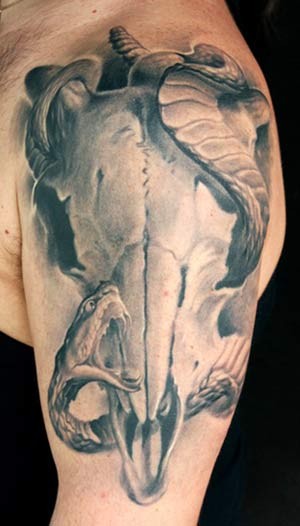 Grey Ink Skull With Snake Tattoo On Left Shoulder
