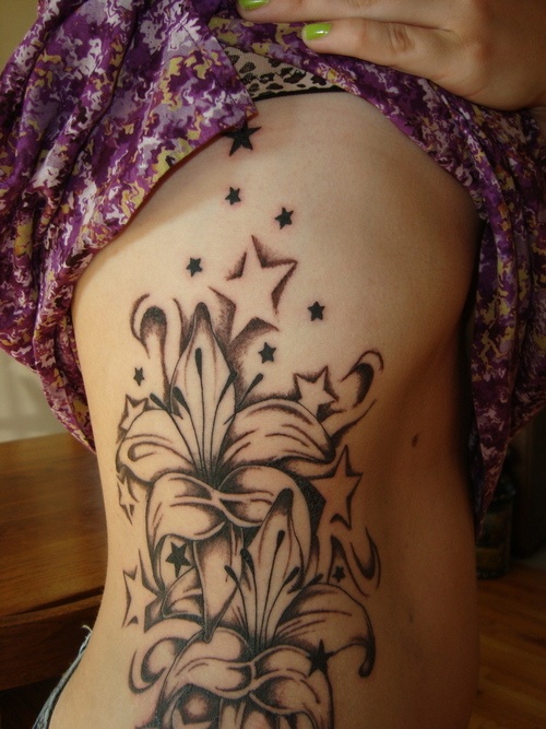Grey Ink Stars And Lily Flower Tattoos On Side Rib