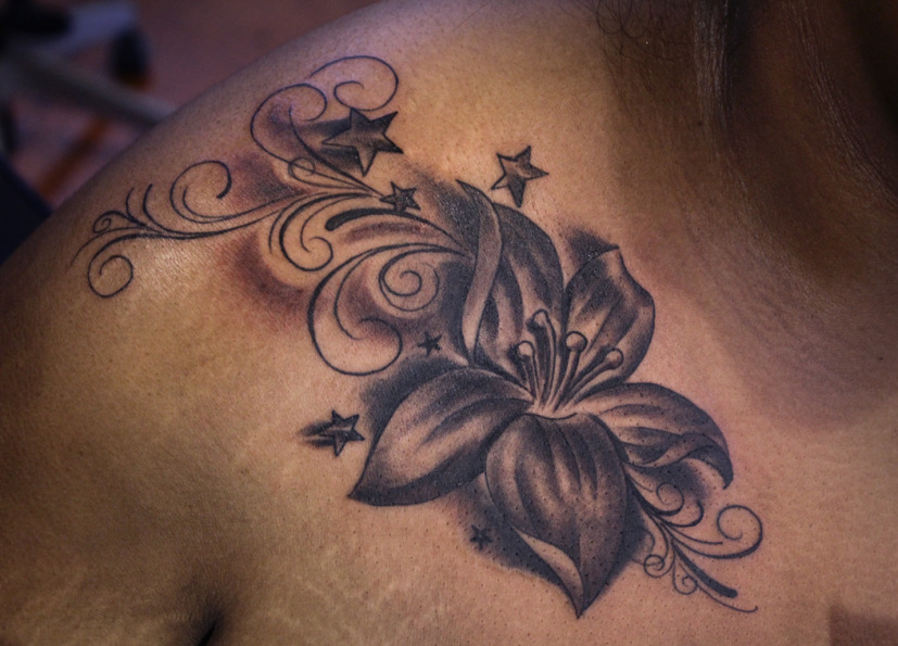 Grey Stars And Lily Flower Tattoo On Front Shoulder