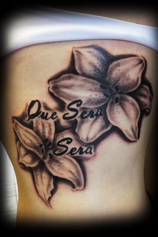 Que Sera Black And Grey Lily Tattoo On Girl Side Rib