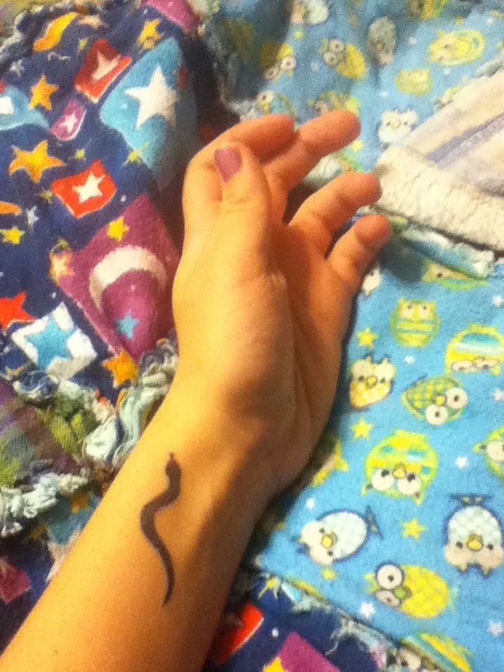 Simple Black Ink Snake Tattoo On Girl Left Wrist
