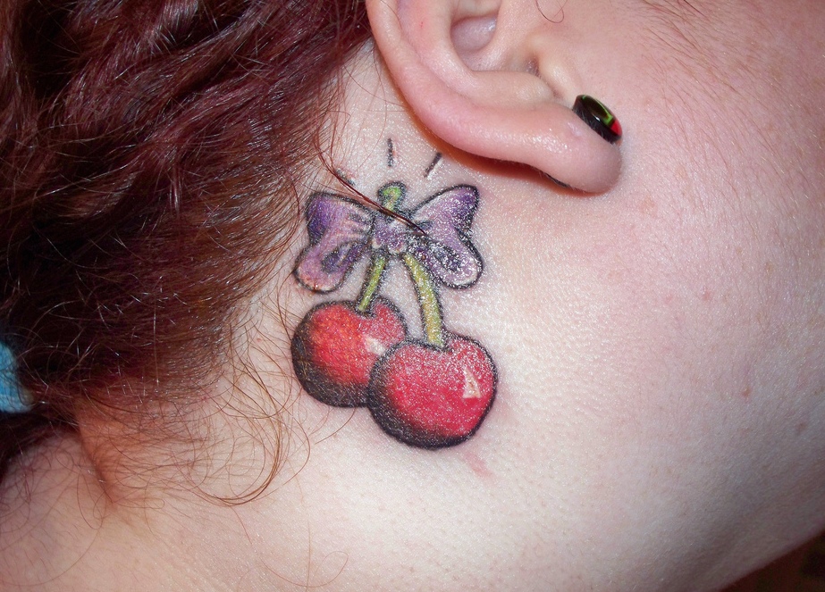 Small Bow And Cherry Tattoo On Girl Side Neck