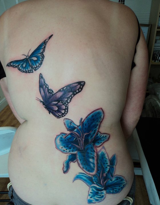 Traditional Lily Flowers With Butterflies Tattoo On Full Back