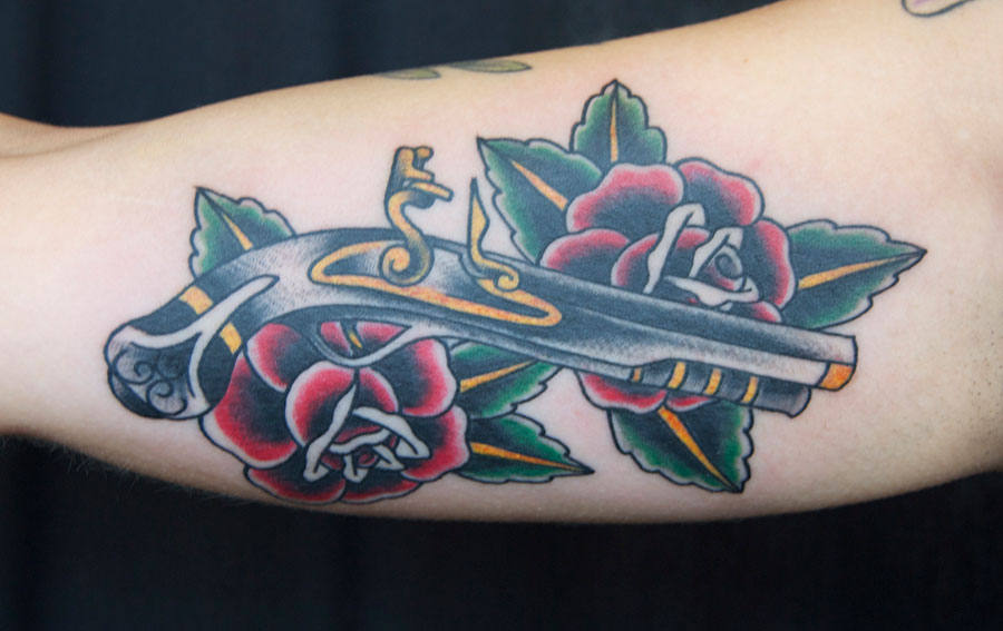Traditional Pirate Gun With Roses Tattoo On Half Sleeve
