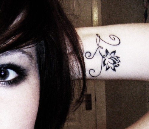 Wonderful Black Lotus Flower Tattoo On Girl Left Wrist
