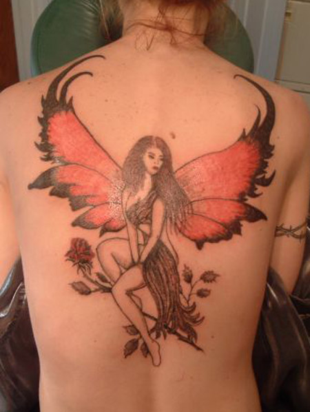 Wonderful Fairy With Flowers Tattoo On Upper Back