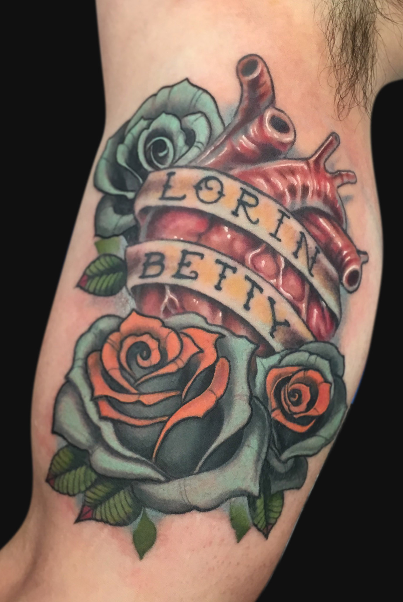 Amazing Real Heart With Roses And Banner Tattoo On Bicep