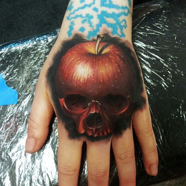 Attractive Apple Skull Tattoo On Left Hand By Mick Squires