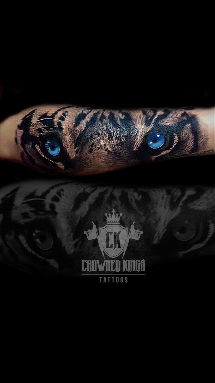 Awesome Blue Tiger Eyes Tattoo On Arm by Crowned Kings