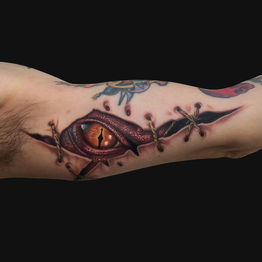 Awesome Ripped Skin Dragon Eye Tattoo On Man Left Bicep
