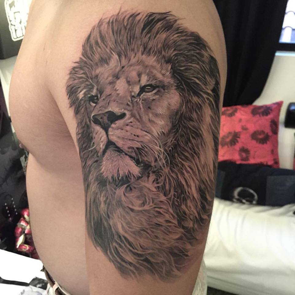 Black And Grey Lion Head Tattoo On Man Left Half Sleeve