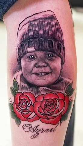 Black Ink Baby Face With Red Roses Tattoo On Right Leg Calf