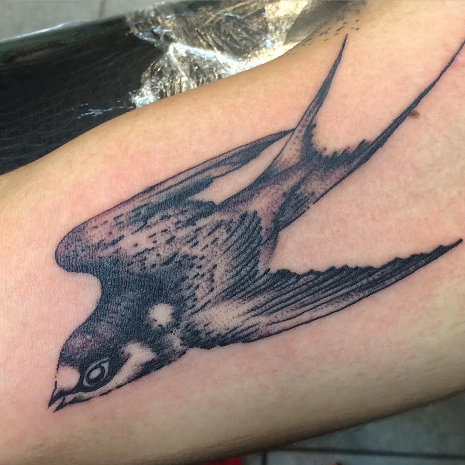 Black Ink Flying Bird Tattoo On Half Sleeve