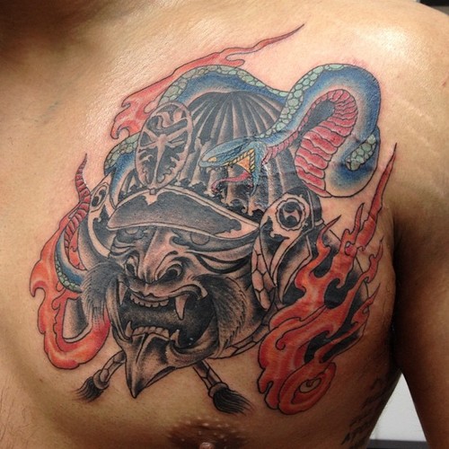 Black Ink Samurai Head With Snake Tattoo On Man Left Chest