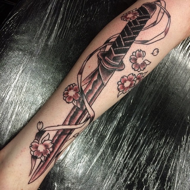 Black Ink Samurai Sword With Flowers Tattoo Design For Leg
