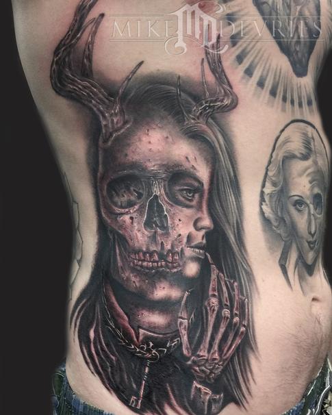 Black Ink Skull With Girl Face Tattoo On Man Right Side Rib By Mike Devries