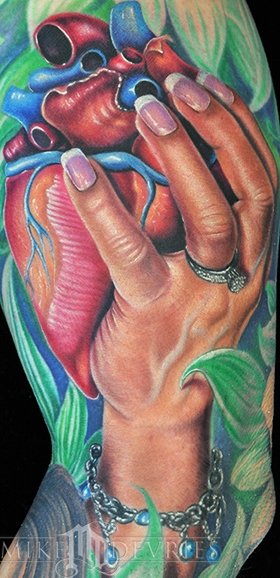 Colorful Real Heart In Hand Tattoo On Left Half Sleeve By Mike Devries