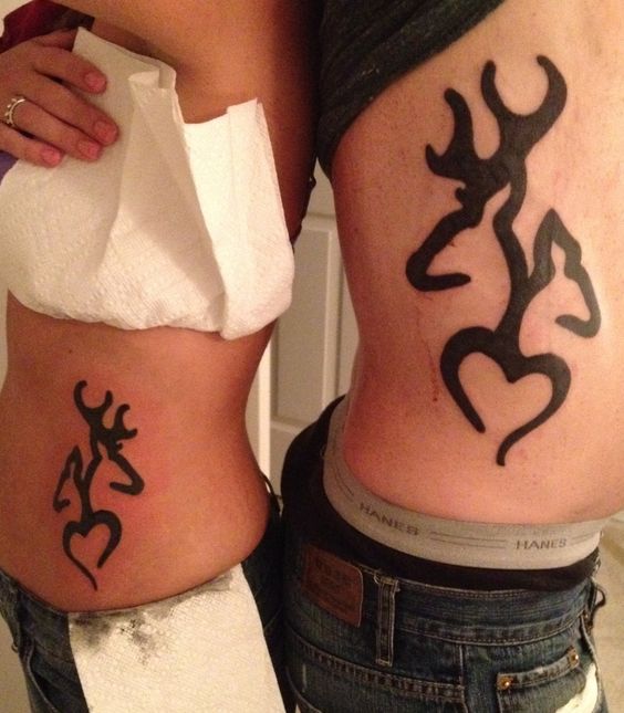 Couple Showing Side Rib Deer Tattoos