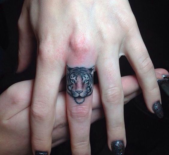 Cute Small Tiger Face Tattoo On Middle Finger by Joe Ellis
