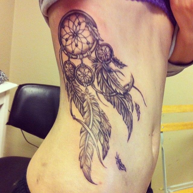 Grey Ink Dreamcatcher Tattoo On Girl Side Rib by Chris Trevino
