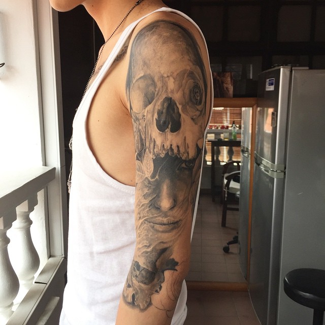 Grey Ink Skull Tattoo On Man Left Half Sleeve By Elvin