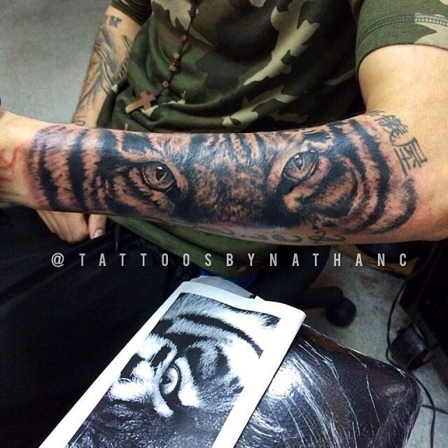 Grey Ink Tiger Eyes Tattoo On Left Arm by Nathanc
