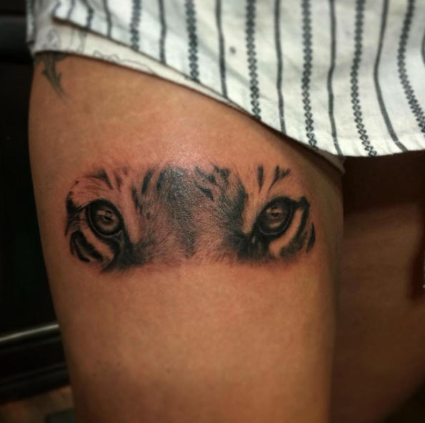 Grey Ink Tiger Eyes Tattoo On Thigh