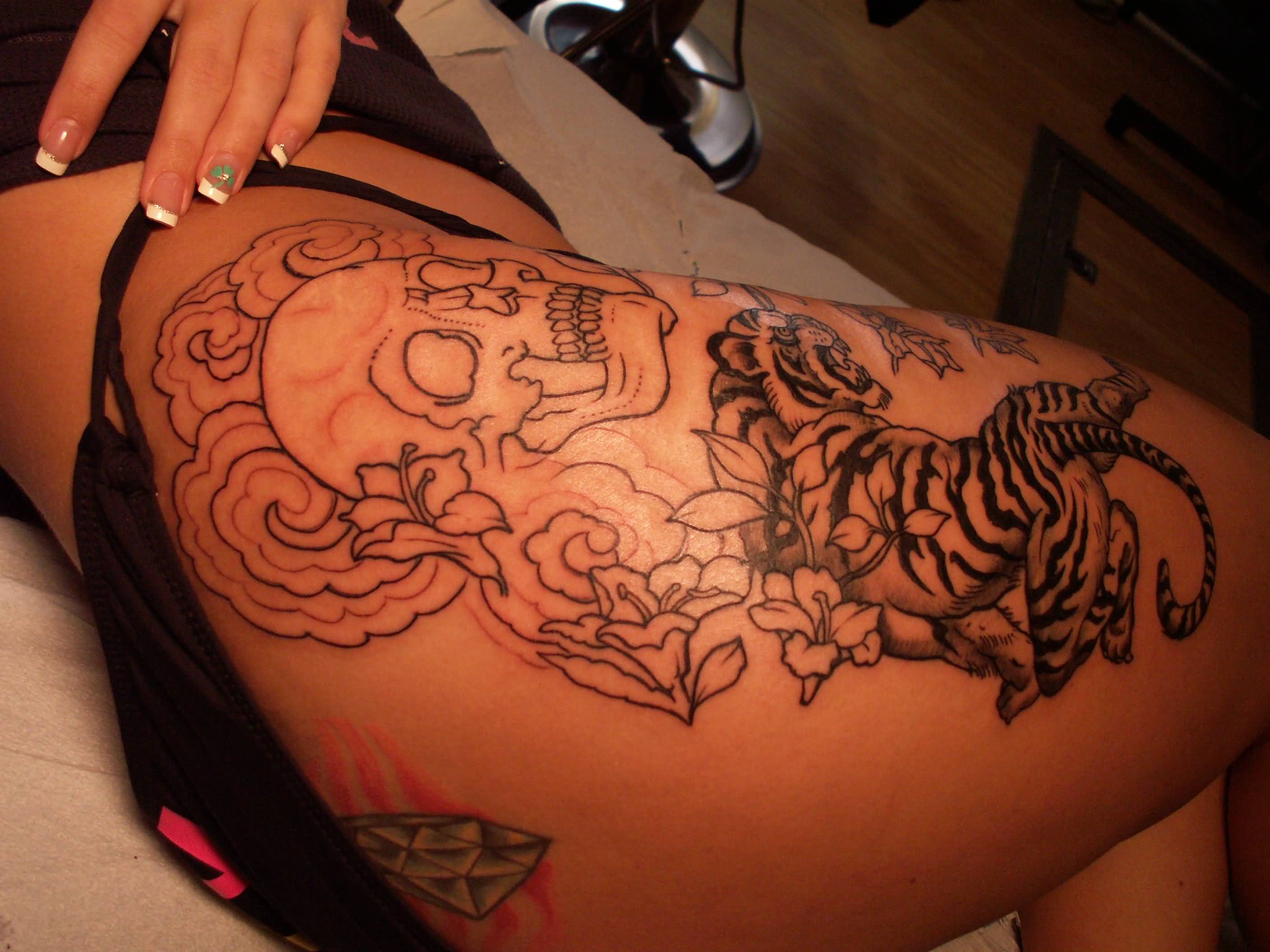 Outline Skull And Tiger Tattoo On Thigh.