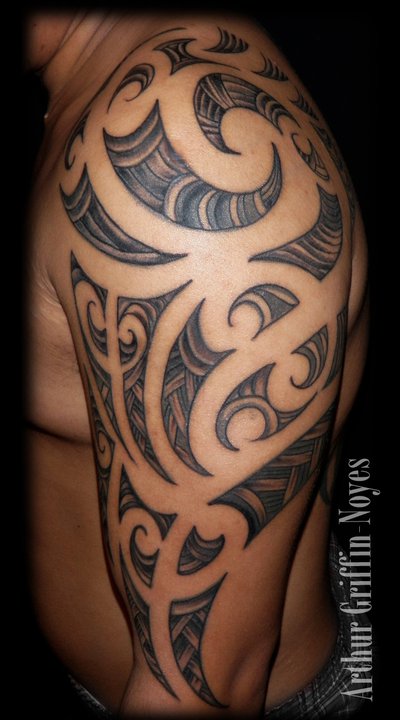 Attractive Black Ink Tribal Design Tattoo On Man Left Half Sleeve By Arthur Griffin Noyes
