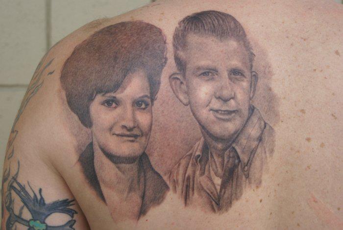 Black And Grey Man And Women Face Portrait Tattoo On Left Back Shoulder