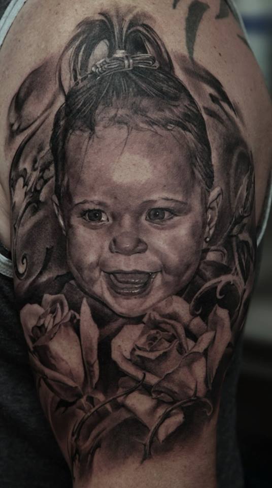 Black Ink Baby Portrait With Rose Tattoo On Left Half Sleeve