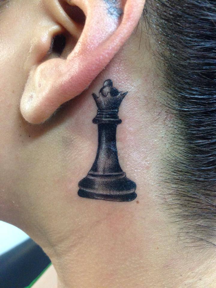 Black Ink Chess Queen Tattoo On Women Left Behind The Ear